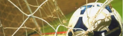 [photo: close up of football in net]
